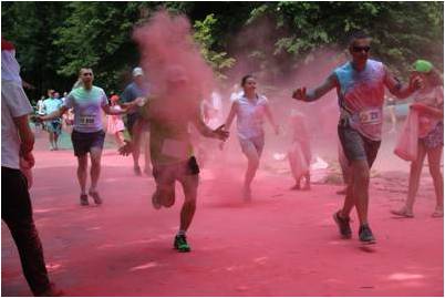 ludzie biegnący w chmurze różowego pyłu