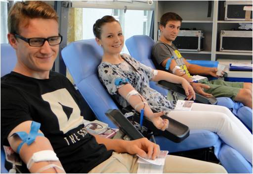 Trójka młodych ludzi w fotelach oddaje krew