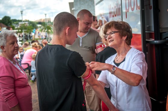 Zdjęcie - pielęgniarka zawiązuje krwiodwacy opaskę na ramieniu