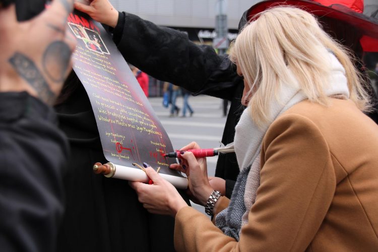 Zdjęcie: kobieta podpisuje plakat
