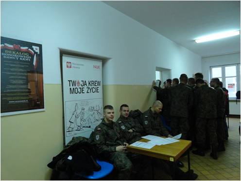 Zdjęcie: żołnierze pod plakatem kampanii